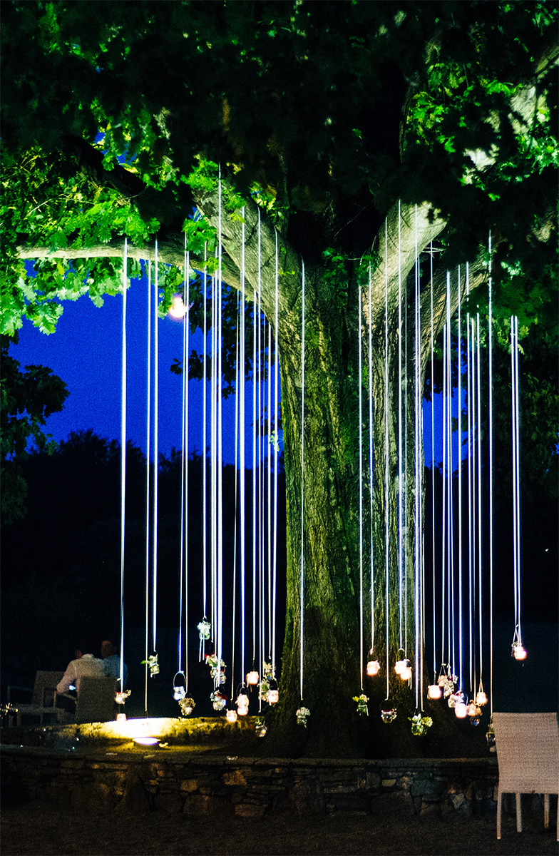 Candles Hanging From An Oak Light Up The Garden At Night For Par