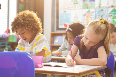 School Kids Writting On Notebook In Classroom At School