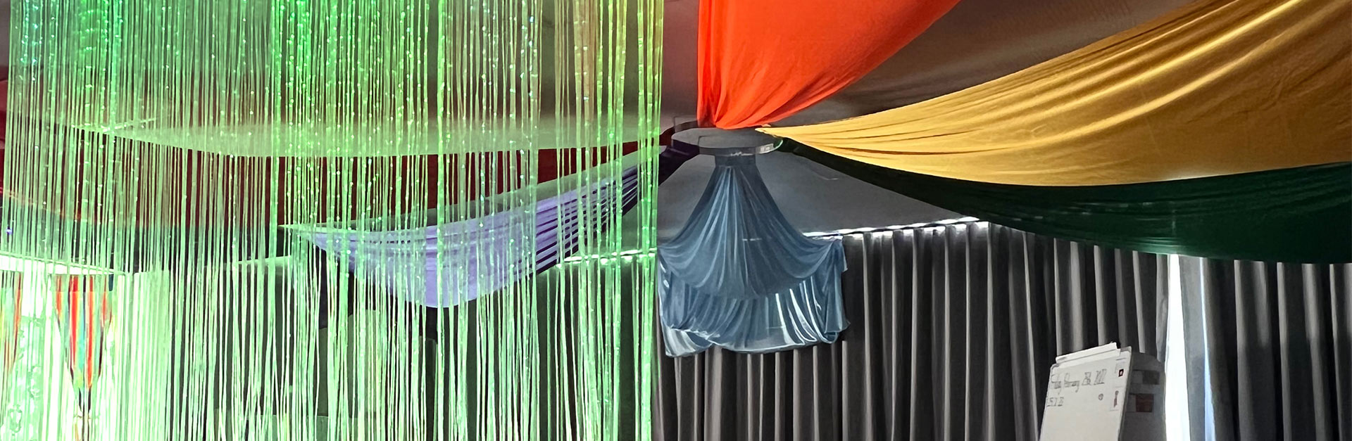 A snippet of a green fiber optic curtain in a sensory room