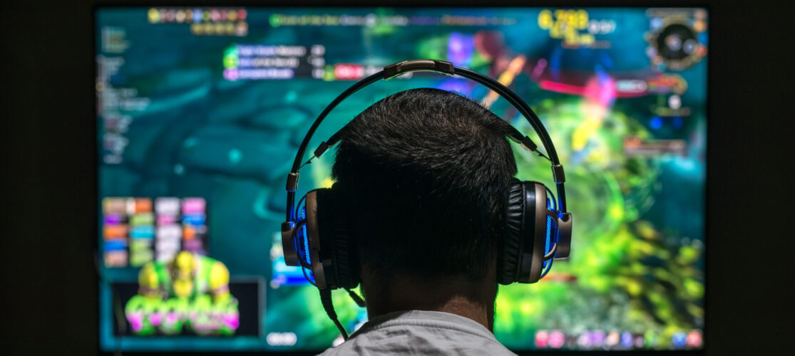 Young Gamer Playing Video Game Wearing Headphone.