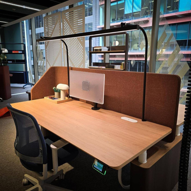 LightEFX Shift desk light installed on a commercial office hot desk with privacy screen and monitor